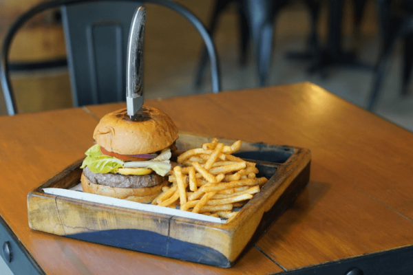 doubel stacked burger and fries on butting board